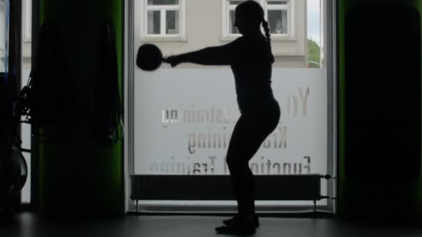 Silhouette Femme Potelée Dans Salle Gym Soulève Une Kettlebell Noire — Video