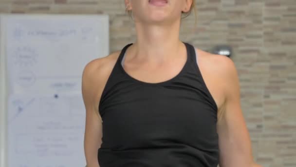 体操でスキップロープを使用して行使若い女性 体育館で一生懸命練習するアスリートウーマン — ストック動画