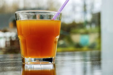 Bir bardak portakal suyu üzerinde ahşap bir masa ile.