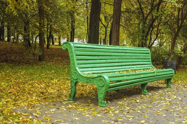 A bench in the park in autumn and around yellow leaves. — Stock Photo, Image