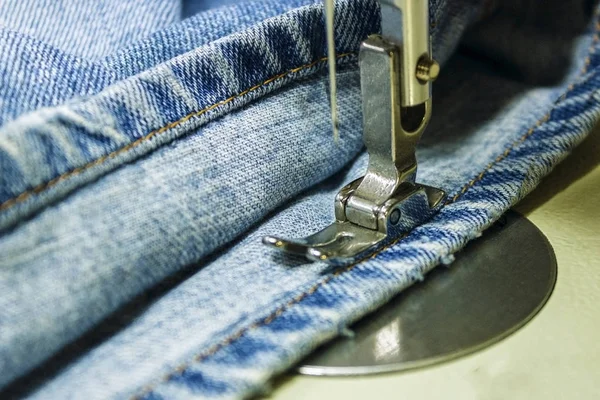 Denim kumaş dikiş makinesi üzerinde. Dikiş prosedürü Close-Up