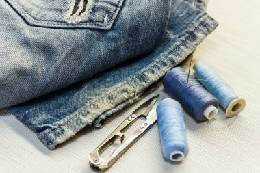 Dikiş masaya kot konu ve makas ile vardır. CL