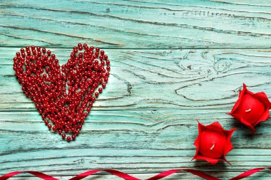 Kırmızı kalp Boncuk Ahşap turkuaz arka plan üzerinde kazıklı. C