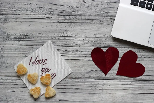 Arka plan ile dizüstü bilgisayar tanımlama bilgisi ahşap bir masa üzerinde bir Valentine