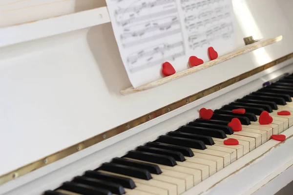 Κόκκινες καρδιές κοσμούν πλήκτρα πιάνου. Ημέρα του Αγίου Βαλεντίνου . — Φωτογραφία Αρχείου