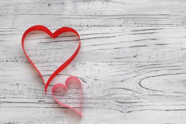 Bir beyaz ahşap arka plan şerit üzerinde iki kalp yaptı. Valenti