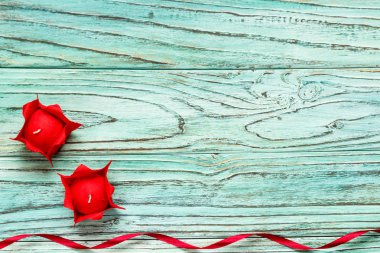 Turkuaz ahşap arka plan üzerinde kırmızı renkteki iki mum. , 