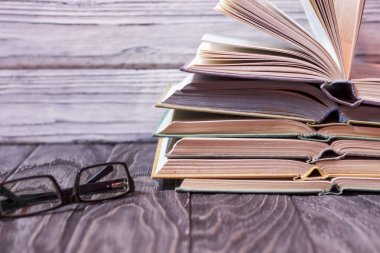 Ahşap bir masa üzerinde renkli kitap yığını. ha okuma kavramı