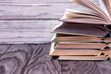 Ahşap bir masa üzerinde renkli kitap yığını. ha okuma kavramı