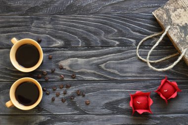 Koyu ahşap arka plan üzerinde iki bardak kahve, kırmızı p vardır