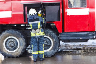Bir kırmızı itfaiye duran ve bir oksijen tutan bir itfaiyeci 