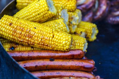 Taze sosis ızgara mısır yakın çekim ile pişirilir. Adam