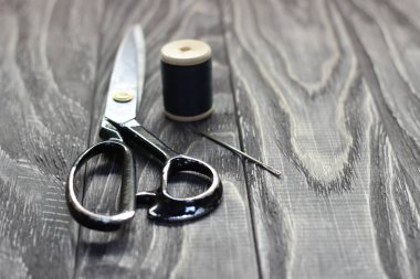 Üzerinde siyah ahşap kokusu, yakın çekim, makas iplik makarası ile iğne.