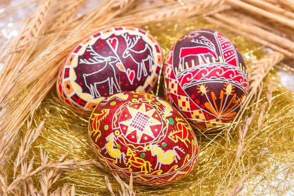 Three red Easter eggs with wheat — Stock Photo, Image