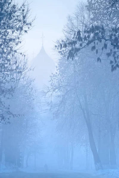 Man φιγούρα περπατά στην ομίχλη στην εκκλησία σε χιονισμένο δρόμο στη Ρωσία χειμώνα — Φωτογραφία Αρχείου