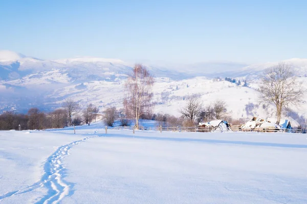 Alpendorf auf winterlichen Berghügeln — Stockfoto