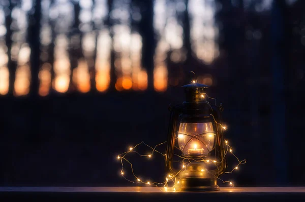Винтажная лампа со свечой и огнями ночью — стоковое фото