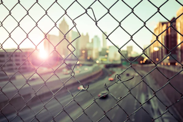 Ciudad de la mañana horizonte a través de la valla de malla de alambre —  Fotos de Stock