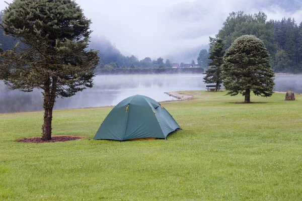Namiot kempingowy na zielony trawa trawnik w pobliżu jeziora — Zdjęcie stockowe
