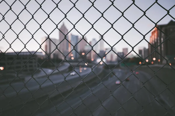 Grunge City Skyline durch den Maschendrahtzaun — Stockfoto