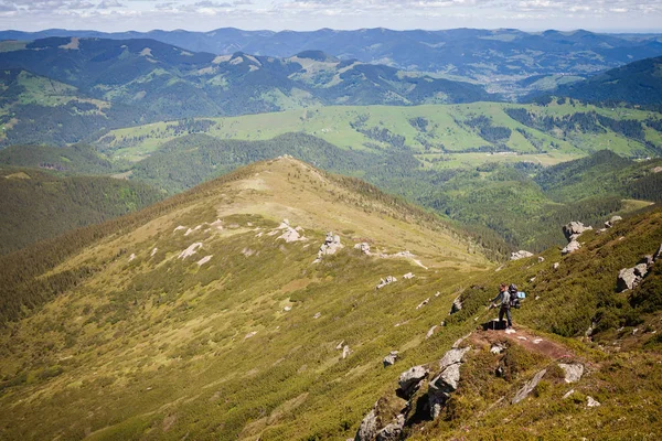 Letní horská krajina s mužem stojící na skalnatém kopci — Stock fotografie