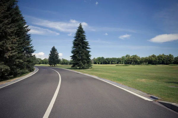 Aszfalt road a modern város zöld park — Stock Fotó