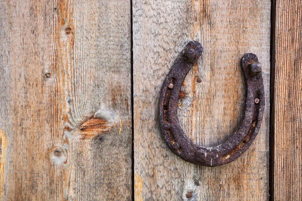 Old grunge horse shoe on wooden background — Stock Photo, Image