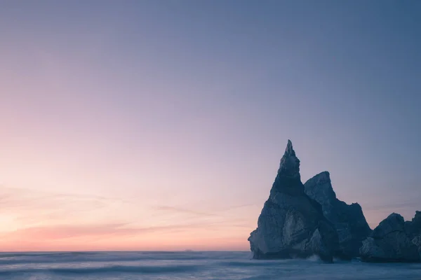 Praia rochosa bonita no crepúsculo — Fotografia de Stock