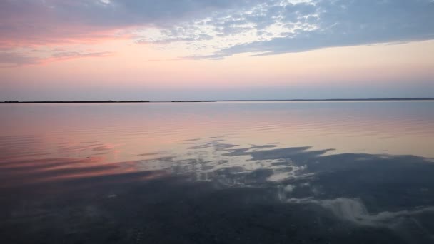 Pôr do sol colorido sobre a superfície calma da água do oceano — Vídeo de Stock