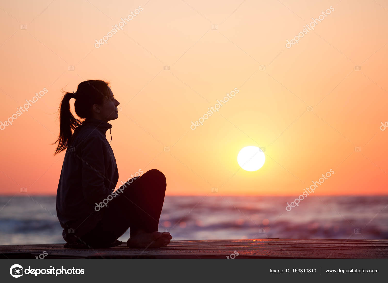 Lonely Girl Sitting On The Sunrise Beach  Stock Photo  Khoroshkov 163310810-7399