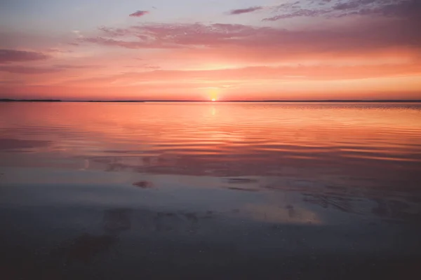 Colorful beautiful cloudy sunset over ocean surface — Stock Photo, Image