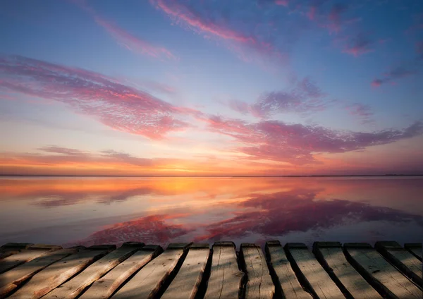 Colorido hermoso atardecer nublado sobre la superficie del océano — Foto de Stock