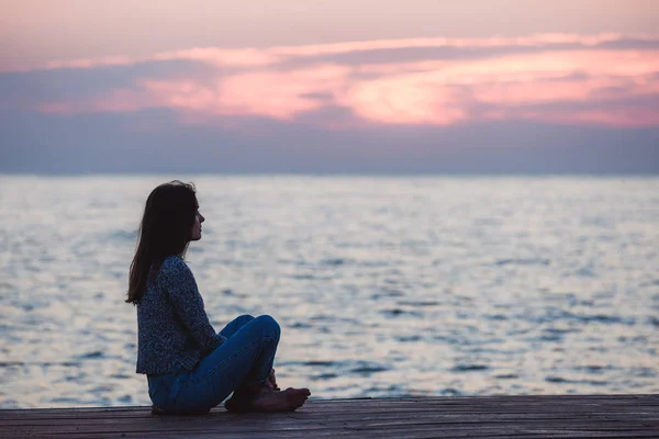Самотня дівчина сидить на східному пляжі — стокове фото
