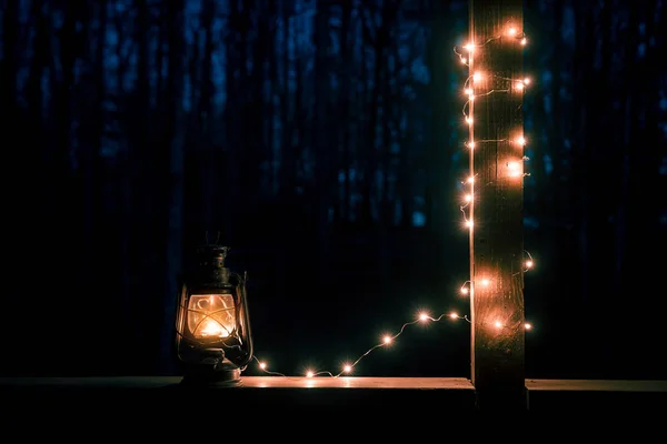 Eski stil fener karanlık ormanın arka plan üzerinde ışıkları ile — Stok fotoğraf