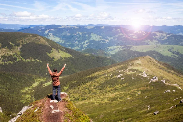 Człowiek stojący na szczycie góry i patrząc na horyzoncie — Zdjęcie stockowe