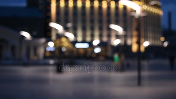 Fond flou avec des lumières de la ville floues et les gens qui marchent sur la place — Video