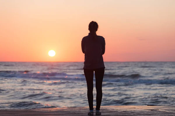 Einsames Mädchen am Strand von Sonnenaufgang — Stockfoto