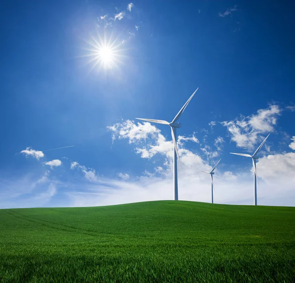 Estación de aerogeneradores en césped de hierba verde sobre azul soleado s —  Fotos de Stock