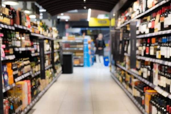 Abstrato corredor supermercado borrado com prateleiras coloridas e clientes irreconhecíveis como fundo — Fotografia de Stock