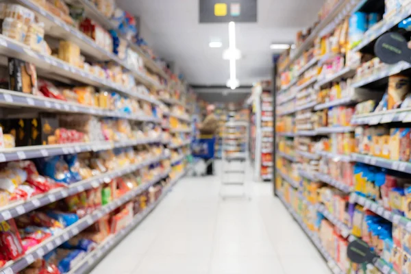 Abstrato corredor supermercado borrado com prateleiras coloridas e clientes irreconhecíveis como fundo — Fotografia de Stock