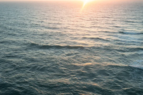 Vista aérea sobre el océano de sol saliendo sobre la superficie de las olas de agua —  Fotos de Stock