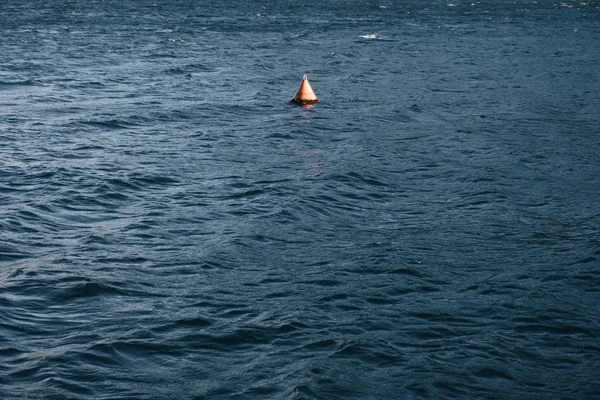 Red floating buoy on stormy sea surface — Stockfoto
