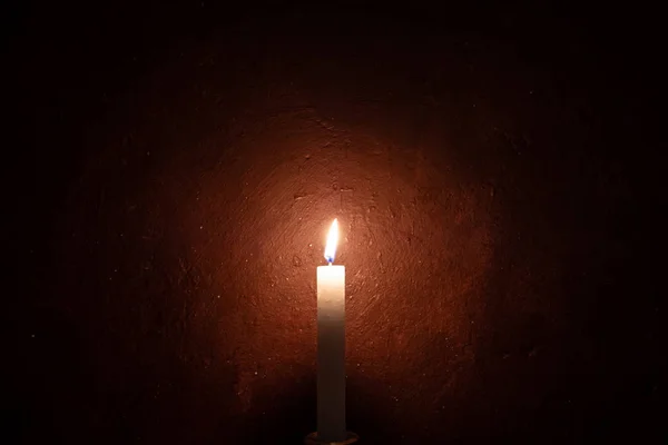 Uma vela queimando, fundo de parede grungy e vinheta — Fotografia de Stock