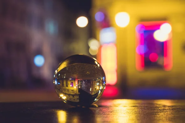 夜市街道通过水晶玻璃球模糊了背景 — 图库照片