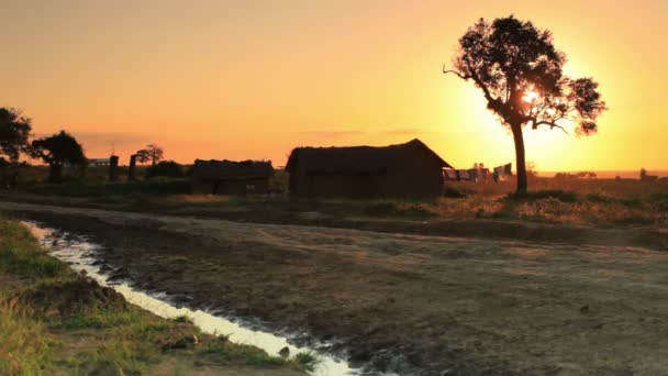 Estrada de terra e casas ao pôr do sol — Vídeo de Stock