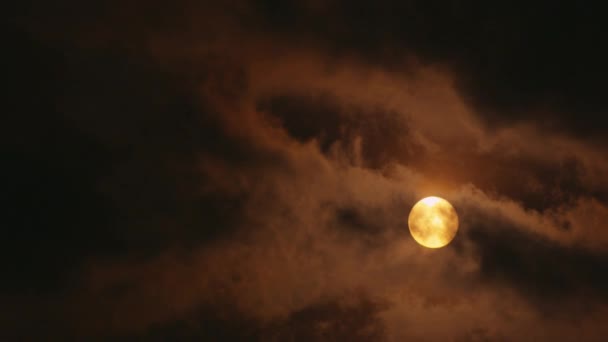 Luna amarilla llena brillando a través de nubes — Vídeo de stock