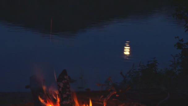 Reflexión de la luna en el lago por fogata — Vídeos de Stock