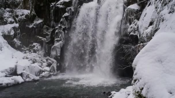 Lenta pan-up uma cachoeira espetacular coberta de neve — Vídeo de Stock