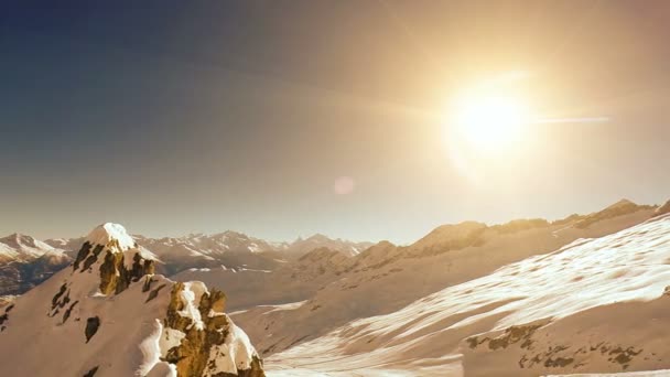 Εναέρια θέα των χιονισμένων βουνών που πετούν πάνω από το ηλιοβασίλεμα — Αρχείο Βίντεο