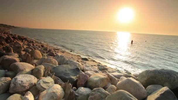 Pływak w oceanu na kamienistej plaży — Wideo stockowe